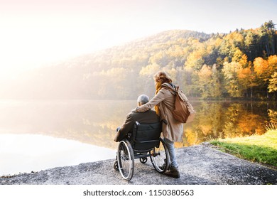 Senior couple with wheelchair in autumn nature. - Powered by Shutterstock