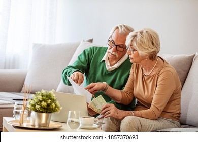 Senior couple working on their finances using a laptop. Shot of a senior couple looking worried while going through paperwork together at home. Worried senior couple checking their bills at home - Powered by Shutterstock