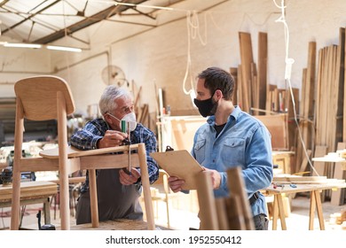 Senior Craftsman And Furniture Maker Apprentice With Face Mask Because Of Covid-19