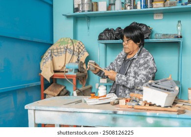 Senior craftsman sanding wood in his workshop, surrounded by tools and materials, meticulously crafting a piece - Powered by Shutterstock