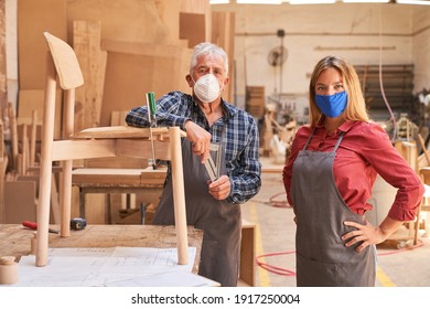 Senior Craftsman And Woman As An Apprentice With Face Mask In The Cabinet Maker