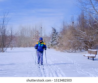 Senior Cross-country Skier Skiing In Missouri, Midwest, On Clear Winter Day; Trees In Background 