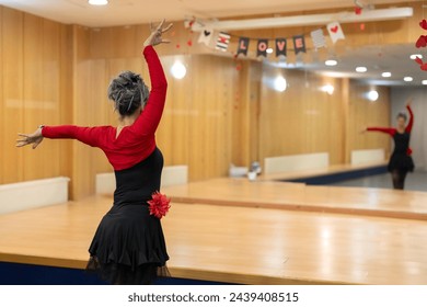 A senior dancer poses in a classroom dance class - Active seniors attend dance classes - Powered by Shutterstock