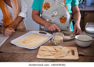 Senior And Daughter Cooking Together At Home - Grandma Showing And Teach How To Cook Fish - Have Fun And Happy Moment Indoor - Eating At The Kitchen - Mature Woman With Glasses And Retired 60s