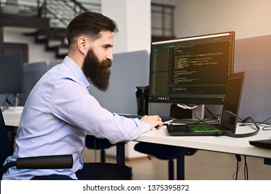 Senior Developer Working On Computer In IT Office, Sitting At Desk And Coding, Working On A Project In Software Development Company Or Startup. High Quality Image.