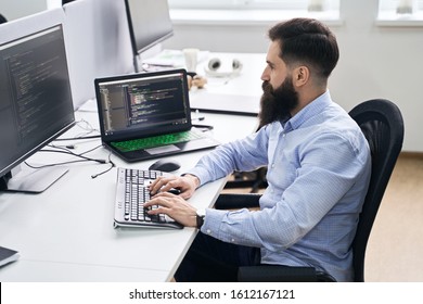 Senior Developer Working On Computer In IT Office, Sitting At Desk And Coding, Working On A Project In Software Development Company Or Technology Startup.