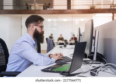 Senior Developer Working On Computer In IT Office, Sitting At Desk And Coding, Working On A Project In Software Development Company Or Technology Startup.