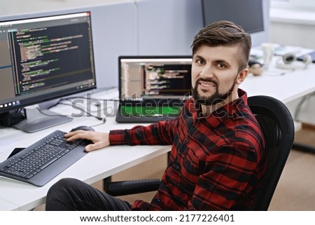 Senior developer working on computer in IT office, sitting at desk and coding, working on a project in software development company or technology startup.