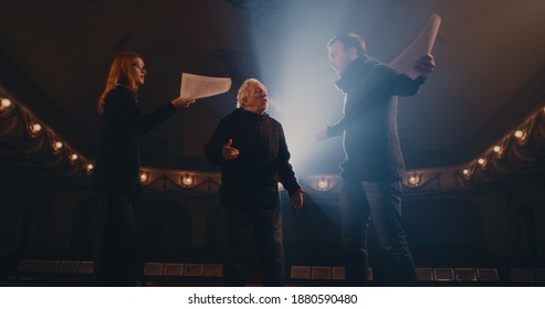 Senior Director Helping Man And Woman To Act Out Argument Scene During Rehearsal On Stage In Theater