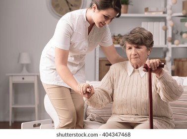 Senior Disabled Woman Standing Up With Carer's Help