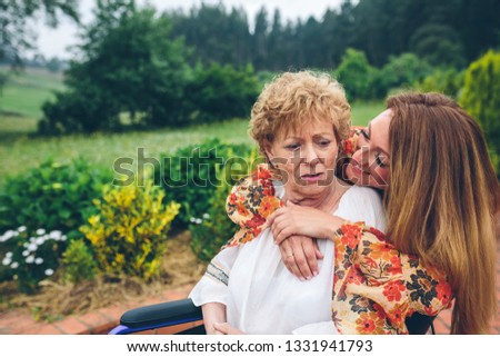 Similar – Young woman talking to elderly woman in wheelchair