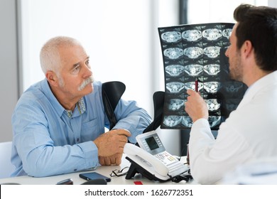 Senior Doctor Explaining Xray To Patient