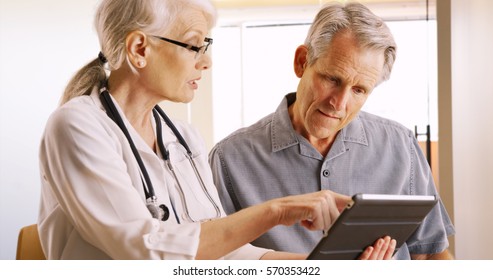 Senior Doctor Expressing Health Concerns With Elderly Man Patient