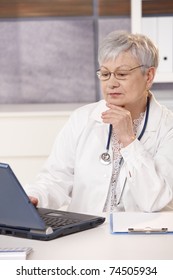 Senior Doctor Looking At Computer Screen, Thinking.?