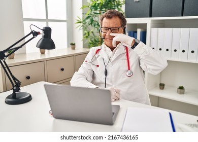 Senior Doctor Man Working On Online Appointment Pointing With Hand Finger To Face And Nose, Smiling Cheerful. Beauty Concept 