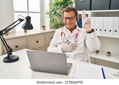 Senior Doctor Man Working On Online Appointment Smiling Swearing With Hand On Chest And Fingers Up, Making A Loyalty Promise Oath 