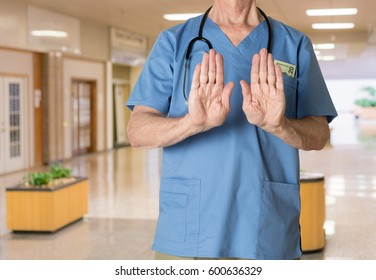 Senior doctor in scrubs refusing entry - Shutterstock ID 600636329