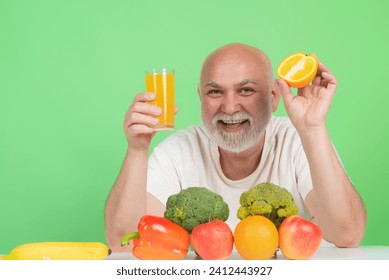 Senior drink orange juice in studio. Elderly man hold glass of orange juice. Man with orange juice. Fruit for aged people. Senior on diet, healthy lifestyle. Studio portrait senior with orange juice - Powered by Shutterstock