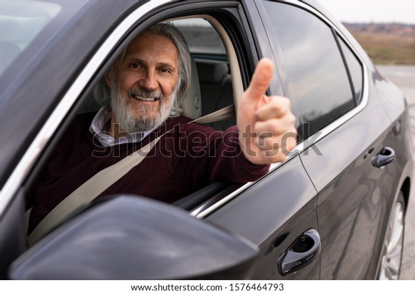 Senior driver showing\
them up from the car