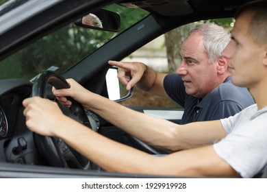 Senior Driving Instructor Giving Instructions To Student