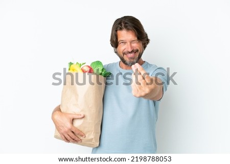 Senior dutch man holding grocery shopping bag over isolated background making money gesture