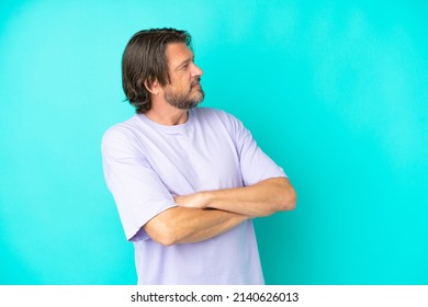 Senior dutch man isolated on blue background looking to the side