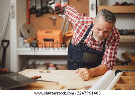 senior elderly engineer worker back pain muscle cramp from hard working prolonged standing at work