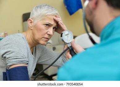 Senior Elderly Lady Receiving Bad News About Her Blood Pressure From Her Doctor Or A Nurse