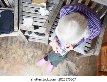 Senior Elderly Person Keeping Mind Active By Doing Crossword Puzzle