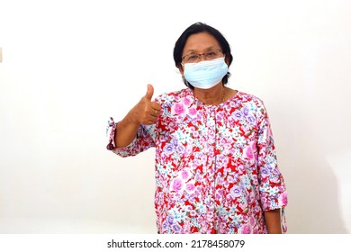 Senior Elderly Woman Standing And Wearing Face Mask While Showing Thumbs Up. Isolated On White