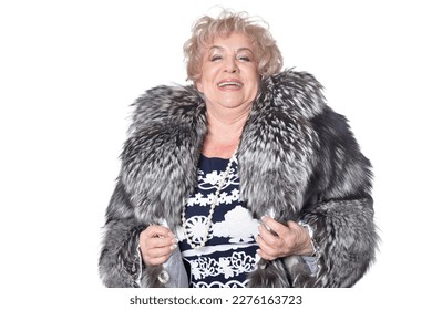 Senior emotional woman in fur coat posing isolated on white background