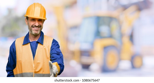 Senior engineer man, construction worker holds hands welcoming in handshake pose, expressing trust and success concept, greeting at work - Powered by Shutterstock