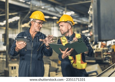 senior engineer talking explain machine working process for teaching training young male worker at heavy industry factory