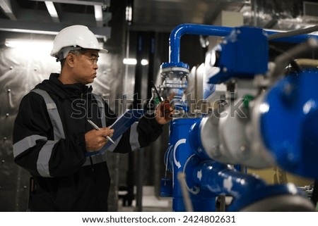 A senior engineer is testing the energy flow to inspect the quality of equipment on the piping system.