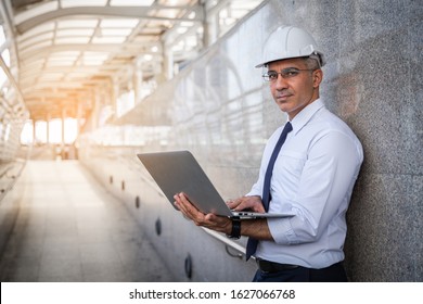 Senior engineer using a tablet computer in a outdoor work site factory.
