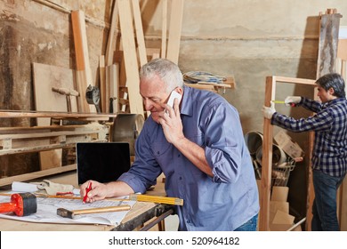 Senior as executive chief with smartphone at carpentry shop - Powered by Shutterstock