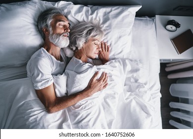 Senior family couple sleeping together in bed.