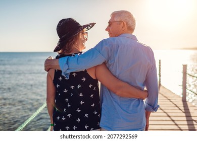 Senior Family Couple Walking On Pier By Red Sea. Retired People Enjoying Vacation In Tropical Egypt Enjoying Landscape. Back View