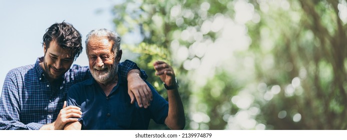 senior father with adult son in family concept banner background with copy space, elderly old man person are happy and enjoy with hipster son together by walking outdoor in nature