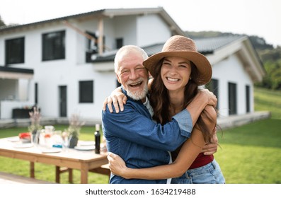 Senior father with daughter outdoors in backyard, looking at camera. - Powered by Shutterstock