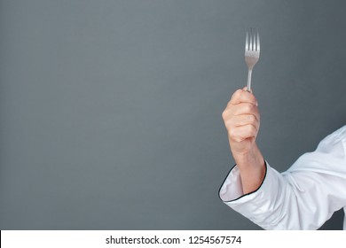 Senior Female Chef Studio Standing Isolated On Gray Wall Holding Fork Hand Close-up