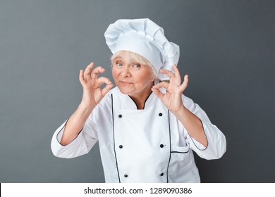 Senior Female Chef Studio Standing Isolated On Gray Wall Looking Camera Showing Silence Gesture Smiling Calm