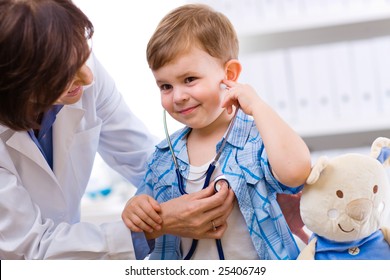 Senior Female Doctor Examining Happy Child, Smiling.