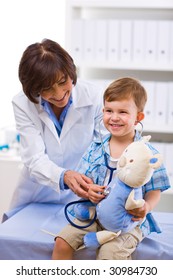 Senior Female Doctor Examining Happy Child, Smiling.