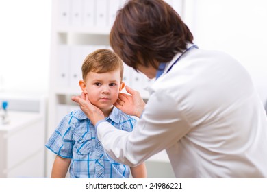 Senior Female Doctor Examining Little Child Boy.