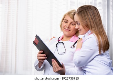 Senior Female Doctor Talking To A Pharmaceutical Sales Representative. Photo Indoor Medical Office, Side Space For Your Ad. High Quality Photo