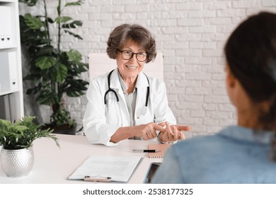 Senior female doctor telling diagnosis, treatment, talking about medications and symptoms. Healthcare and medicine. Patient listening to doctor advice - Powered by Shutterstock