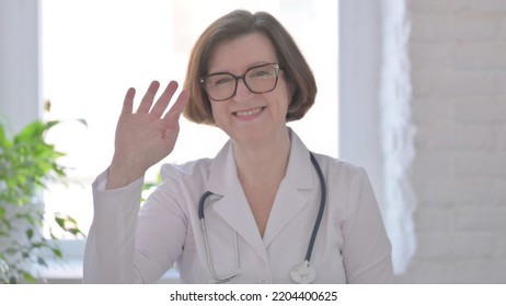 Senior Female Doctor Waving, Welcoming