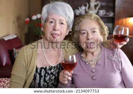 Senior female friends enjoying a cup of wine 
