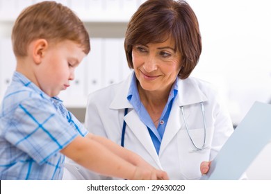 Senior Female  Pediatrician Playing With Child At Doctors Office.